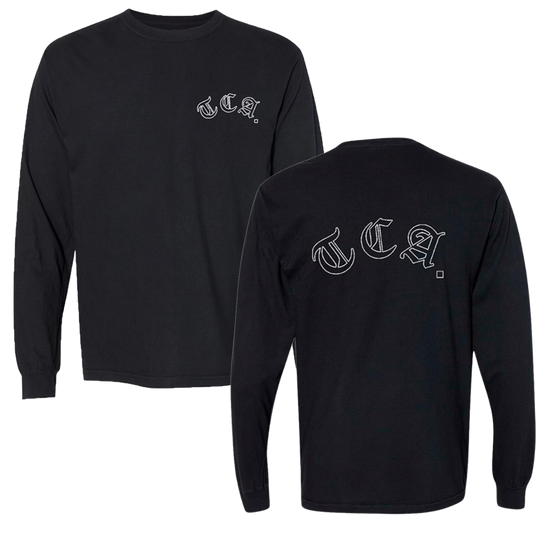 A black long-sleeve shirt with two views. The front features a small 'T.C.A.' logo in white gothic font on the left chest. The back displays the same 'T.C.A.' logo in larger white gothic font across the upper back.