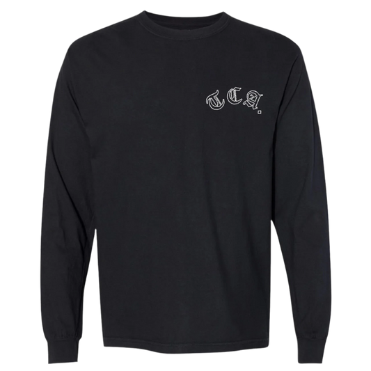 Front view of a black long sleeve The CEO. Apparel shirt with white gothic “TCA.” lettering on the left chest.