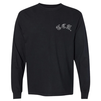 Front view of a black long sleeve The CEO. Apparel shirt with white gothic “TCA.” lettering on the left chest.

